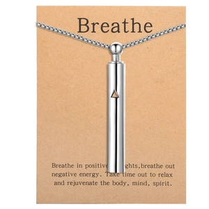 Macro view of silver mindfulness breathing necklace with engraved Kraft paper card
