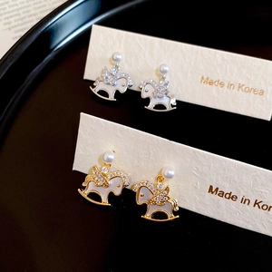 Close-up detail of rocking horse earrings with pearls and pavé cubic zirconia