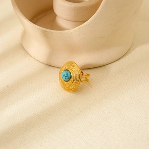 Detailed view of vintage gold ring with turquoise center and rippled disc design