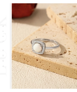 Detailed macro view of S925 sterling silver opal ring on natural sandstone texture