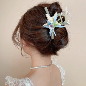 Detail shot of starfish and blue fabric flower hair clip with pearls and small rhinestones