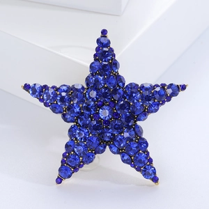 Close-up of star brooch with blue crystals and golden alloy base on a white stand