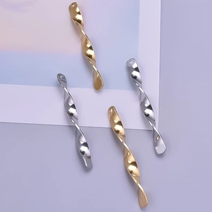 Macro detail of twisted spiral bar pendants with hammered texture in gold and silver