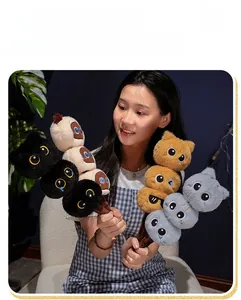 Detailed view of colorful plush cat stack toys held by a model in a warm home setting