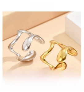 Detailed view of polished gold and silver irregular wavy adjustable stainless steel rings