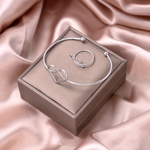 Silver heart open bracelet and matching ring set displayed on a luxury jewelry box
