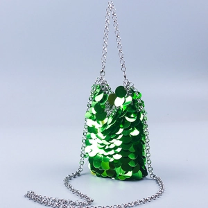 Detailed view of vibrant green fish scale sequins with silver chain strap on bag