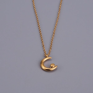 Minimalist 18K gold plated moon pendant necklace with cubic zirconia on a gray background