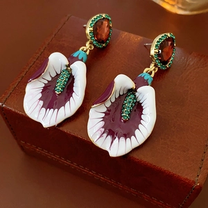 Macro view of vintage enamel flower earrings with sparkling rhinestones and teardrop gems