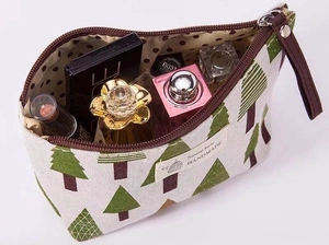 Top view of large canvas makeup bag with tree patterns and polka dot lining storage