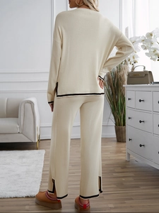 Back view of beige knit lounge set with dark contrast trim on sweater and pants