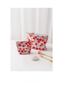 Close-up of pink cherry print makeup bags in two sizes with metal zipper detail