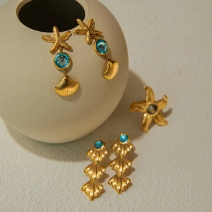 Detailed view of gold starfish and seashell jewelry set with blue gemstones