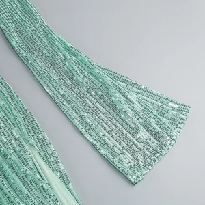 Detail shot of mint green sequins and pleated fabric on a sleeveless evening dress