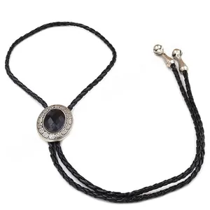 Close-up of black faceted gemstone bolo tie with silver oval slide and braided cord