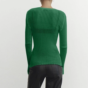 Detail view of the back of a dark green rib-knit long sleeve top with a round neck