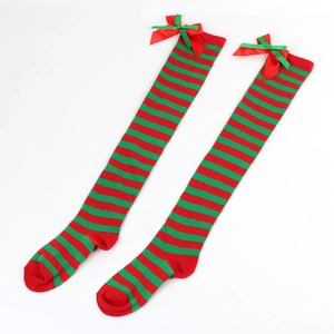 Detail of red and green striped Christmas over-knee socks with satin bow accents