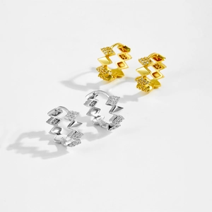 Detailed view of gold and silver S925 rhumbic hoop earrings with sparkling gemstone inlay