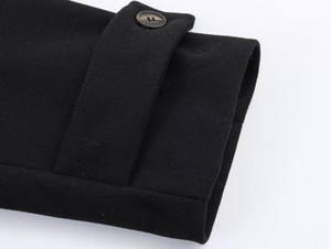 Detailed close-up of a black wool coat cuff featuring a decorative button and adjustable strap