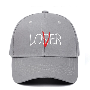 Close-up of grey cotton twill baseball cap featuring LOVER and LOSER letter embroidery