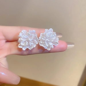 Macro shot of white multilayer flower stud earrings featuring elegant textured petals