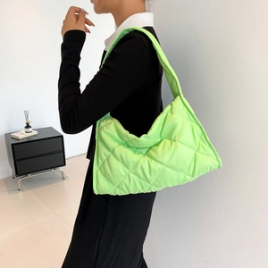 Quilted lime green nylon shoulder bag with oversized puff design worn by model