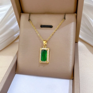 Macro detail of gold necklace featuring emerald green pendant with pavé cubic zirconia