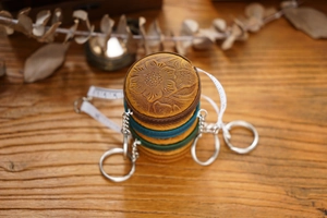 Macro view of vintage crazy horse leather mini tape measure with embossed floral pattern