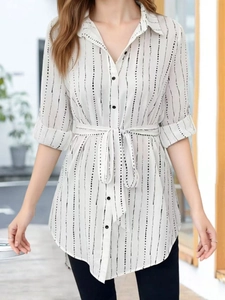 Elegant white lapel dress with black vertical stripes featuring a stylish waist belt