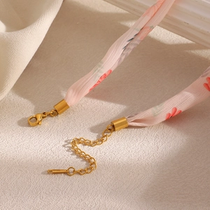 Close-up of pink floral fabric necklace with 18K gold plated clasp and extender chain