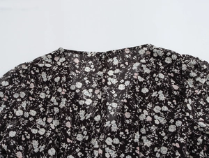 Detailed view of French V-neck floral dress neckline with delicate ruffle shoulders