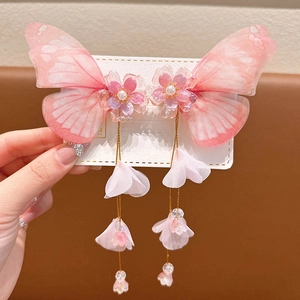 Detailed close-up of pink butterfly hair clips with floral resin accents and long tassels