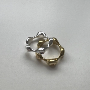Detailed macro shot of irregular wavy minimalist 925 sterling silver rings in gold and silver