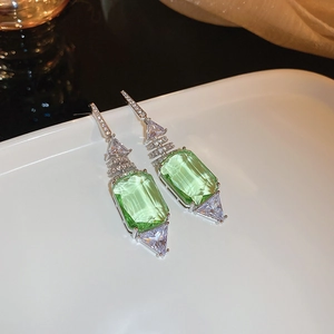 Détail d'une boucle d'oreille en cristal vert taille émeraude avec zircon brillant au style moderne