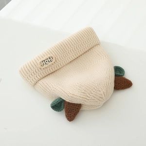 Detailed knit texture of a warm winter baby beanie with horn decor and MOM patch