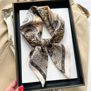 Close-up of vintage paisley printed silk-like square scarf in elegant beige and gold