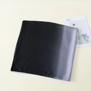 Detail eines Seidenschals mit schwarz-grauem Farbverlauf, flach auf hellem Hintergrund