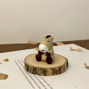 Close-up of hand-carved wooden animal sculpture on a rustic wood slice base