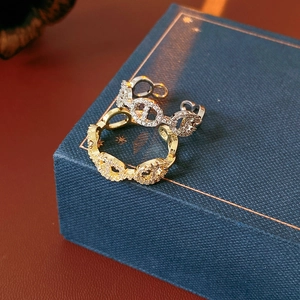 Detail of gold and silver plated link rings with pavé cubic zirconia on jewelry box