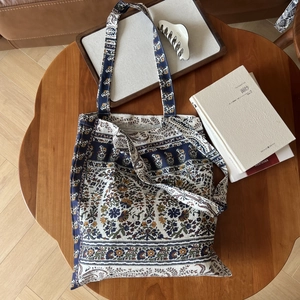 Sac fourre-tout en lin bohème avec imprimé cachemire posé sur une table en bois avec décor