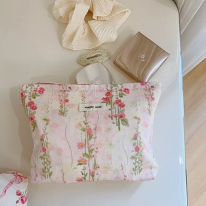 Détail de la trousse à maquillage en coton à fleurs roses avec étiquette simple wish et accessoires