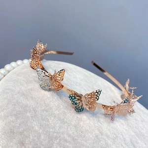 Macro detail of rose gold headband featuring intricate hollow 3D butterfly designs