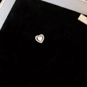 Macro view of heart-shaped earring with halo diamonds and mother-of-pearl inlay