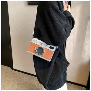 Detail of creative vintage camera crossbody bag with silver and brown faux leather patchwork