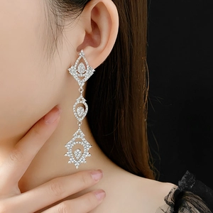 Close-up of long teardrop earrings with silver needles and shimmering cubic zirconia stones