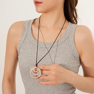 Close-up of silver layered geometric pendant with sparkling rhinestones on black cord
