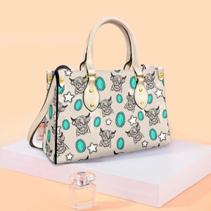 Detail view of Highland cow and turquoise print on faux leather crossbody handbag