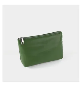 Macro detail of dark green faux leather texture and silver metal zipper on stylish bag