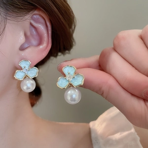 Detail of light blue tulip flower earrings with tassels and elegant pearls on model
