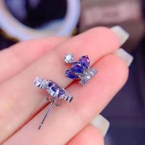 Detailed macro view of crown earrings featuring gradient blue gems and white crystals